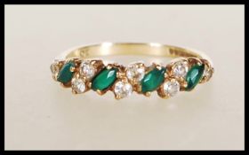 A hallmarked 9ct gold ring set with alternate white and green stones. Hallmarked Birmingham 1992.