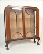 A 1930's Queen Anne revival mahogany china display cabinet being raised claw and ball feet with