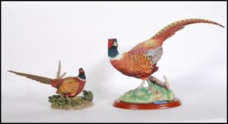 A large ceramic Border Fine Arts pheasant figurine no. A0659 raised on a wooden base together with