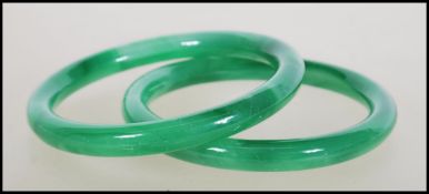 A pair of 20th century Chinese jade slave bangles, each of roundel / doughnut form. Measures 6.