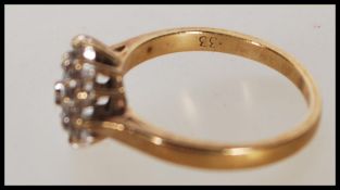 A hallmarked 9ct gold and diamond cluster ring. Ha