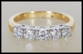 An 18ct yellow gold five stone diamond ring. The d