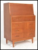 A retro 20th Century teak wood bureau / desk, full front with fully appointed interior over a run of