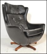 A 1970's retro vintage Parker Knoll statesman swivel and tilt action egg chair having a black