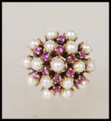 A stamped 585 14ct gold ladies dress ring prong set with seed pearls and pink stones. Weight 5.8g.