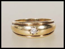A stamped 375 9ct gold ring gypsy set with a round cut diamond. Weight 4.7g. Diamond estimated at