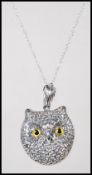 A silver pendant necklace in the form of a owl having glass eyes on a fine link silver chain.