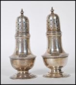 A pair of silver hallmarked table pepperettes by Zachariah Barraclough & Sons, raised on a round