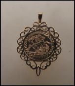 A hallmarked 9ct gold coin pendant having a scrolled design setting with a St George and the