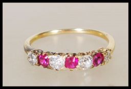 A stamped 18ct yellow gold ring having a decorative pierced mount set with diamonds and rubies.