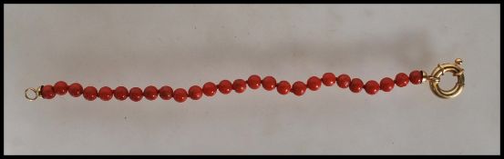 A Chinese 18ct gold and coral bracelet consisting of twenty six coral beads with a 18ct gold