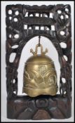 A 20th Century carved Chinese hardwood table top bell having a large carved wood pierced