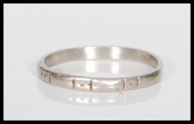 A stamped platinum band ring having engraved geometric decoration. Weight 2.4g. Size M.5.