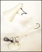 A vintage retro mid 20th Century anglepoise desk lamp by Herbert Terry raised on a white round