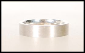 A hallmarked 375 9ct white gold band ring having unpolished surface to outer. Hallmarked for