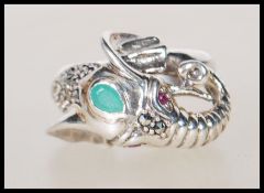 A stamped 925 silver ladies ring in the form of an elephant having ruby eyes with a emerald cabochon