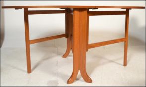 A 1970's 20th century Nathan teak wood drop leaf dining table. The full length drop leaves being