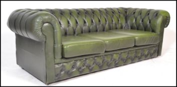 A 20th Century green leather upholstered chesterfield three seater sofa, having buttoned rounded