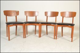 A matching set of four retro 20th Century dining chairs having black vinyl seat pads with shaped
