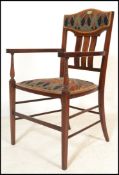 An early 20th Century Edwardian Arts and Crafts mahogany and satin inlaid elbow chair, the shaped