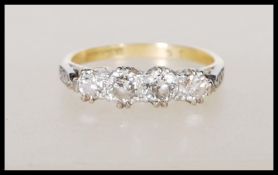 An 18ct yellow gold ring set with four diamonds having platinum shoulders having illusion set