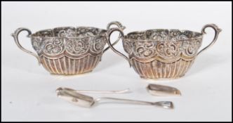 A pair of 19th Century silver hallmarked twin handled table salts, half gadrooned under decorative
