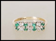 A 9ct gold English hallmarked ring set with two rows of alternate white and green stones. Hallmarked