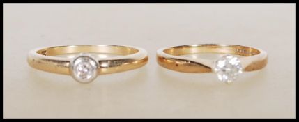 Two hallmarked 9ct yellow gold single stone solitaire diamond rings. One ring having a prong set