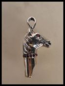 A silver novelty whistle pendant in the form of a horse head set with ruby eyes and having a ruby