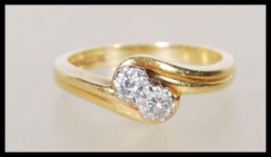 A hallmarked 18ct yellow gold ring having a crossover mount set with round cut diamonds of approx