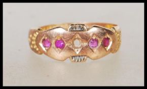 A hallmarked Victorian 15ct gold ring set with four round cut red stones (one missing). Hallmarked