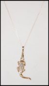 A 9ct gold hallmarked pendant modelled as a Crocodile inset with diamonds set on a fine 9ct gold