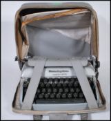 A mid 20th Century vintage Remington Travel-Riter portable typewriter having a grey enamel finish