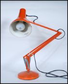 A vintage 20th Century Herbert Terry Industrial anglepoise desk lamp in an orange colourway,