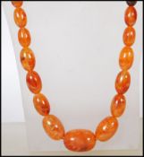 A vintage early 20th Century amber coloured bakelite graduating beaded necklace. Measures approx