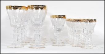 A large collection of glassware having scrolled decoration to the bowls raised on knopped columns on