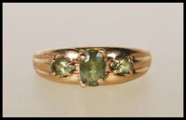 A hallmarked 9ct gold ring with central oval cut green stone flanked by two teardrop green stones on