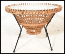 A retro 20th Century atomic style glass topped coffee table, the glass top supported on a whicker