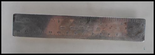 A silver hallmarked ruler measuring in cm from zero to fifteen and in inches from zero to six.