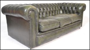 A 20th Century green leather upholstered chesterfield three seater sofa, having buttoned rounded