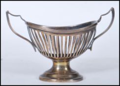A silver hallmarked table cruet having twinned handles and pierced reeded sides raised on a