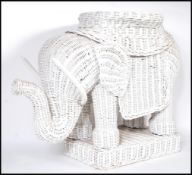 A retro 20th Century whicker work planter modelled as an elephant, the elephant set to a square base