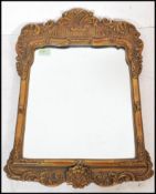 A late 19th Century Victorian rococo style gesso gilt framed wall mirror of rectangular form