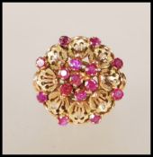 A stamped 14ct gold ladies dress ring having a round flower head with applied pierced decoration