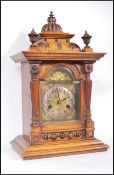 A late 19th / early 20th Century walnut cased brass faced eight day mantel clock, the case of