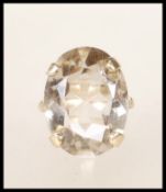 A stamped 9ct ladies dress ring set with an oval cut smokey white stone with foliate and pierced