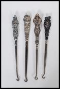 A group of three early 20th Century silver hallmarked button hooks. Each one having a silver