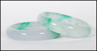 A pair of 20th century Chinese jade slave bangles, each bangle of roundel form. Measures internal
