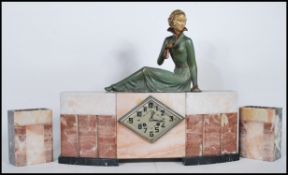 A 1930s French Art Deco veined rouge marble clock garniture set, the movement striking on a bell,