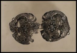 A 20th Century filigree belt buckle in a layered floral design having a hook and eye closure. Marked
